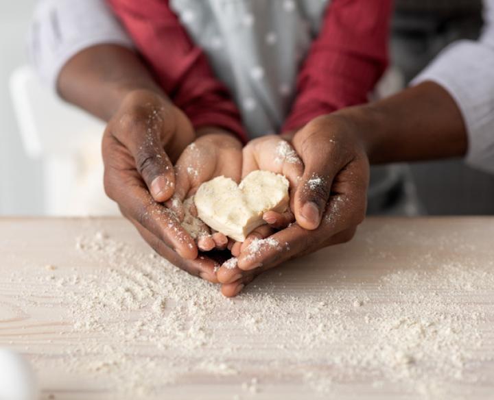 Parent and child baking a heart shaped cookie