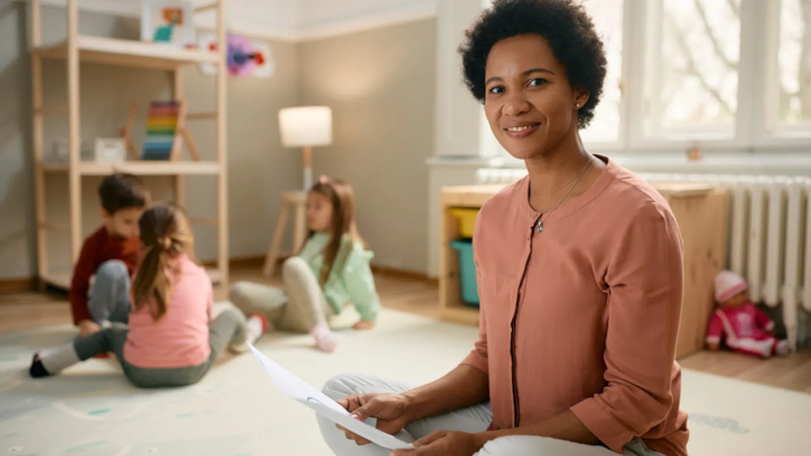 a teacher looking at a tip sheet while working with children