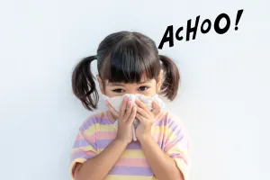 A young girl is sneezing