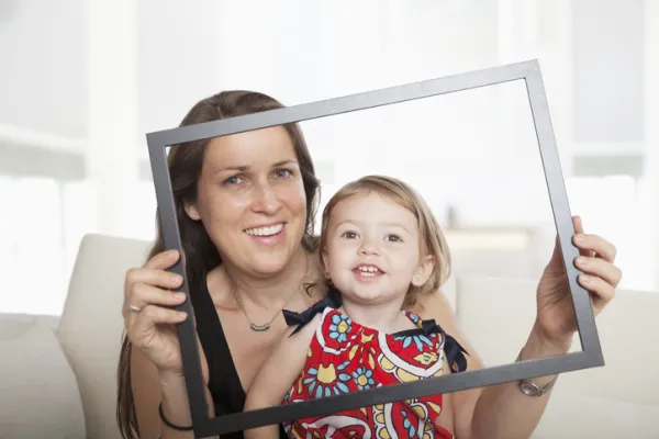Teacher and child looking through empty picture frame