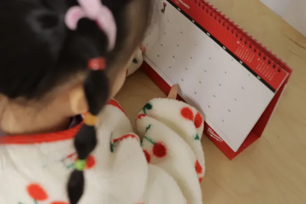 Young girl pointing to a calendar